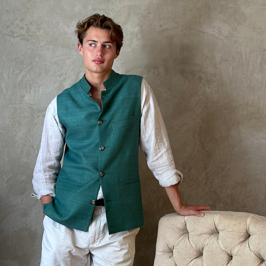 A superb alternative to a jacket in spring and summer or for evening wear with a neat cut and ample pocket space. This pure silk Nehru Style Gilet is handmade in London. Bespoke Options available. Modelled Standing shot showing gilet fully buttoned.