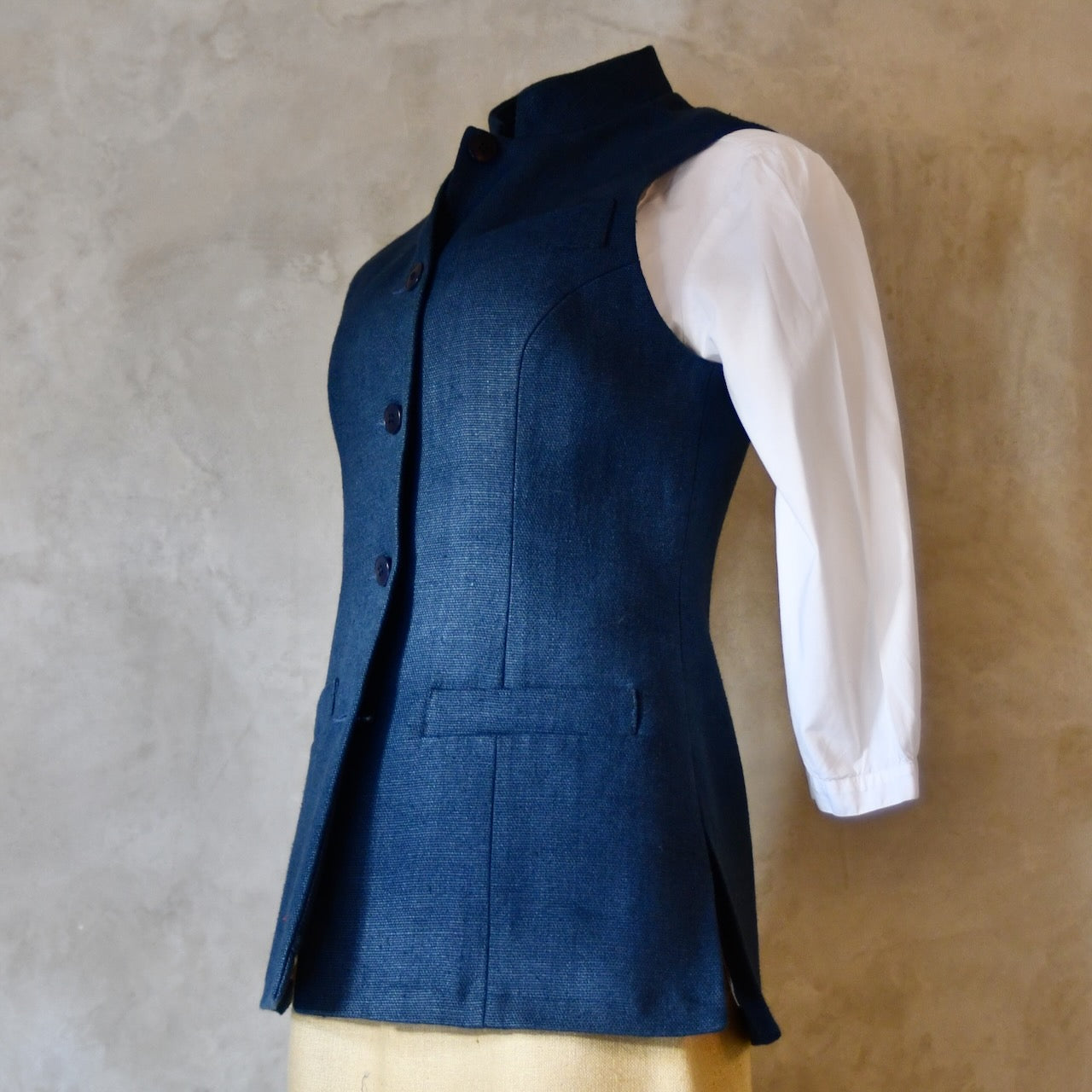 Side Angled Shot of Ladies Gilet in Navy Linen. Made from a Heavy Weight Pure Irish Linen, this waistcoat is hand cut made and finished in London.