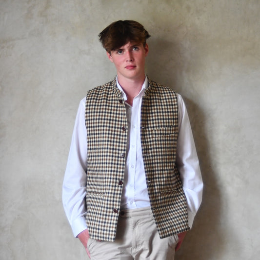 Fitted Nehru-style gilet in pure wool tweed. This gunclub check tweed waistcoat has a softer than usual feel, being made from fabric woven in Somerset. Handmade in London these waistcoats can be ordered in size 26 to 54 and bespoke sizes.
