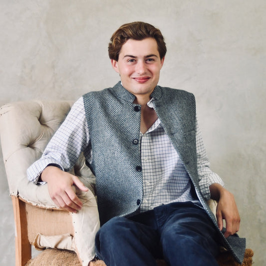 A magical limited edition mid-weight Tailored Cut waistcoat in light grey and blue tiger eye tweed. This tightly woven Yorkshire tweed has an usual patterning giving the overall effect of a mid blue from a distance, it lightens and brightens up on closer inspection as the depths and vivid colours of its patterning are revealed.
Nehru Collar, Striped Ticking lining and a Flat Horn button.
Entirely made in Great Britain.