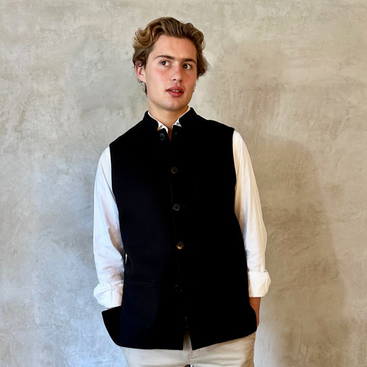 A luxurious pure merino wool flannel Nehru Style gilet. Handmade in London, the gilet has a Nehru Collar, five buttons down the front, three outer pockets and two inside pockets. Woven in Yorkshire.