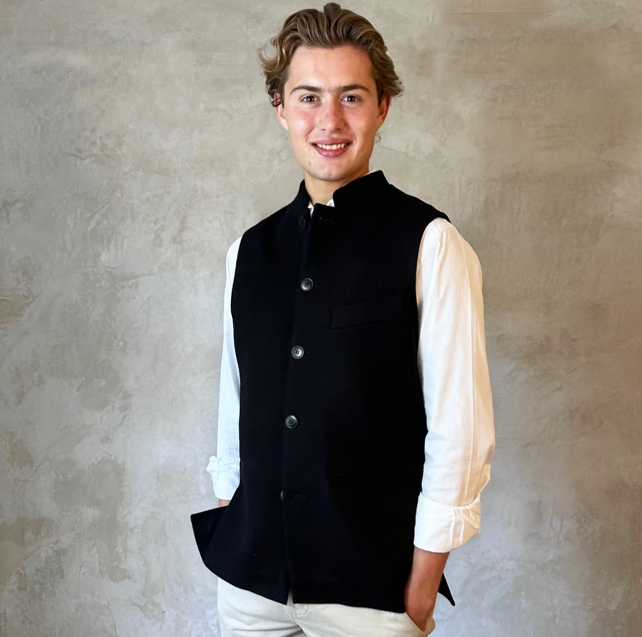 A luxurious pure merino wool flannel Nehru Style gilet. Handmade in London, the gilet has a Nehru Collar, five buttons down the front, three outer pockets and two inside pockets. Woven in Yorkshire. Side View.