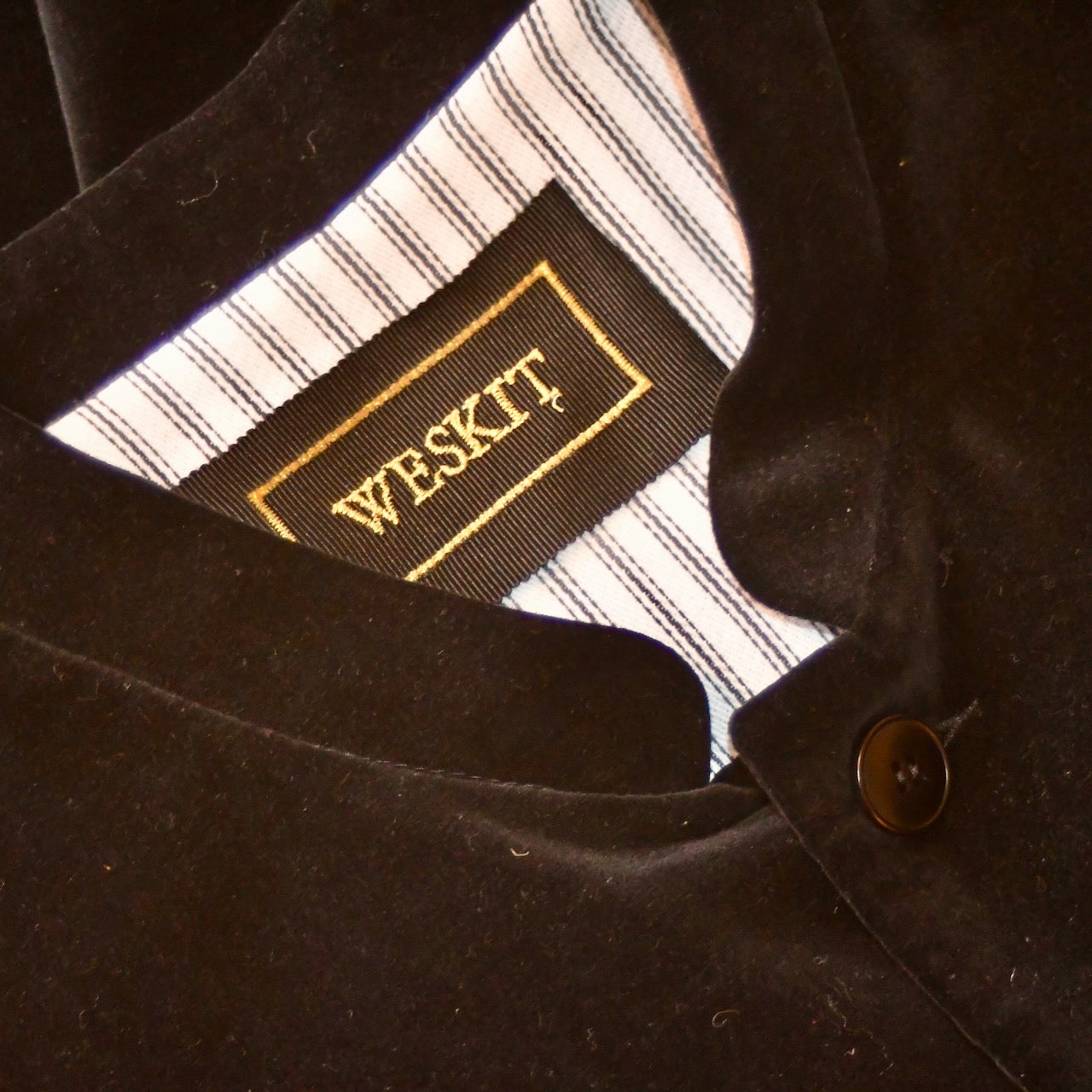 Embroidered Silk Label shown on Weskit Gilet with black velvet  outer on cotton ticking striped lining. Handmade in Great Britain.