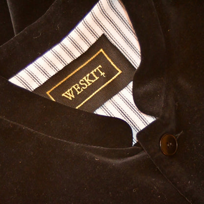 Detail Shot of Bespoke Loose Fit Nehru Style gilet in pure cotton velvet in black. Shot shows mandaarin collar and black embroidered Weskit lable. Entirely made by hand in the United Kingdwom.