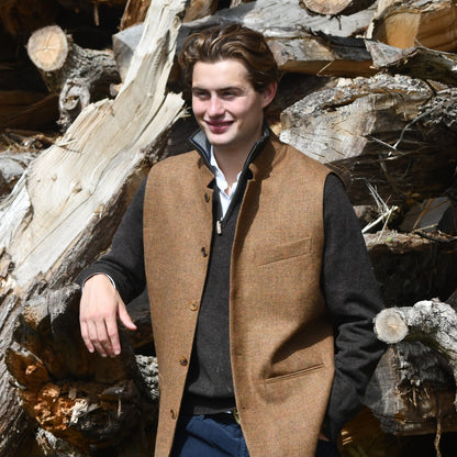 Fitted Nehru style gilet in a lovely orange brown Yorkshire tweed. Three outside and two inside pockets make this a splendid alternative to a jacket. It can be dressed up or down and the finely woven tweed will work as well in the city as in the country. Handmade in London.