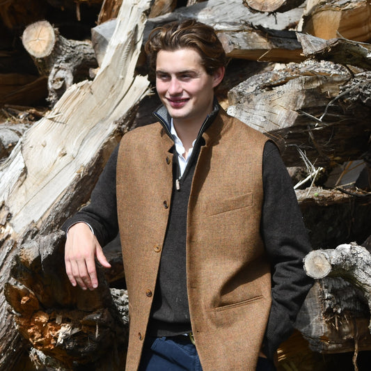 Fitted Nehru style gilet in a lovely orange brown Yorkshire tweed. Three outside and two inside pockets make this a splendid alternative to a jacket. It can be dressed up or down and the finely woven tweed will work as well in the city as in the country. Handmade in London.