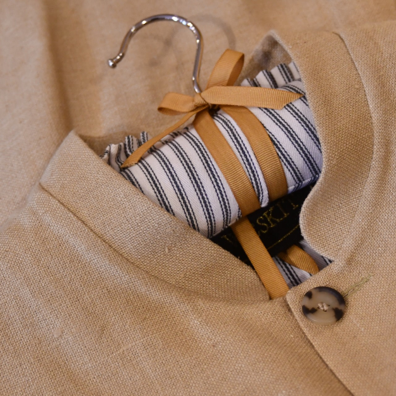 Courtney & Co  Light Cornu buttons made in Gloucestershire for Bespoke Weskit Gilets. Handmade in London. Shown on Bespoke Raffia Silk Matka Gilet.