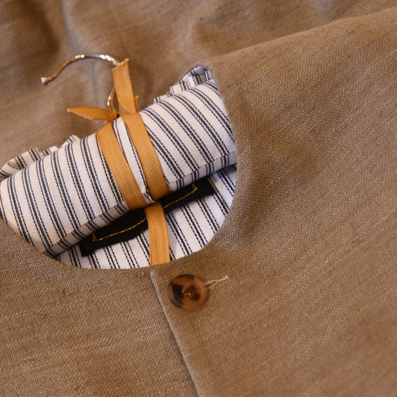 Courtney & Co  Dark Cornu buttons made in Gloucestershire for Bespoke Weskit Gilets. Handmade in London. Shown on Bespoke Khaki Silk Matka Gilet.