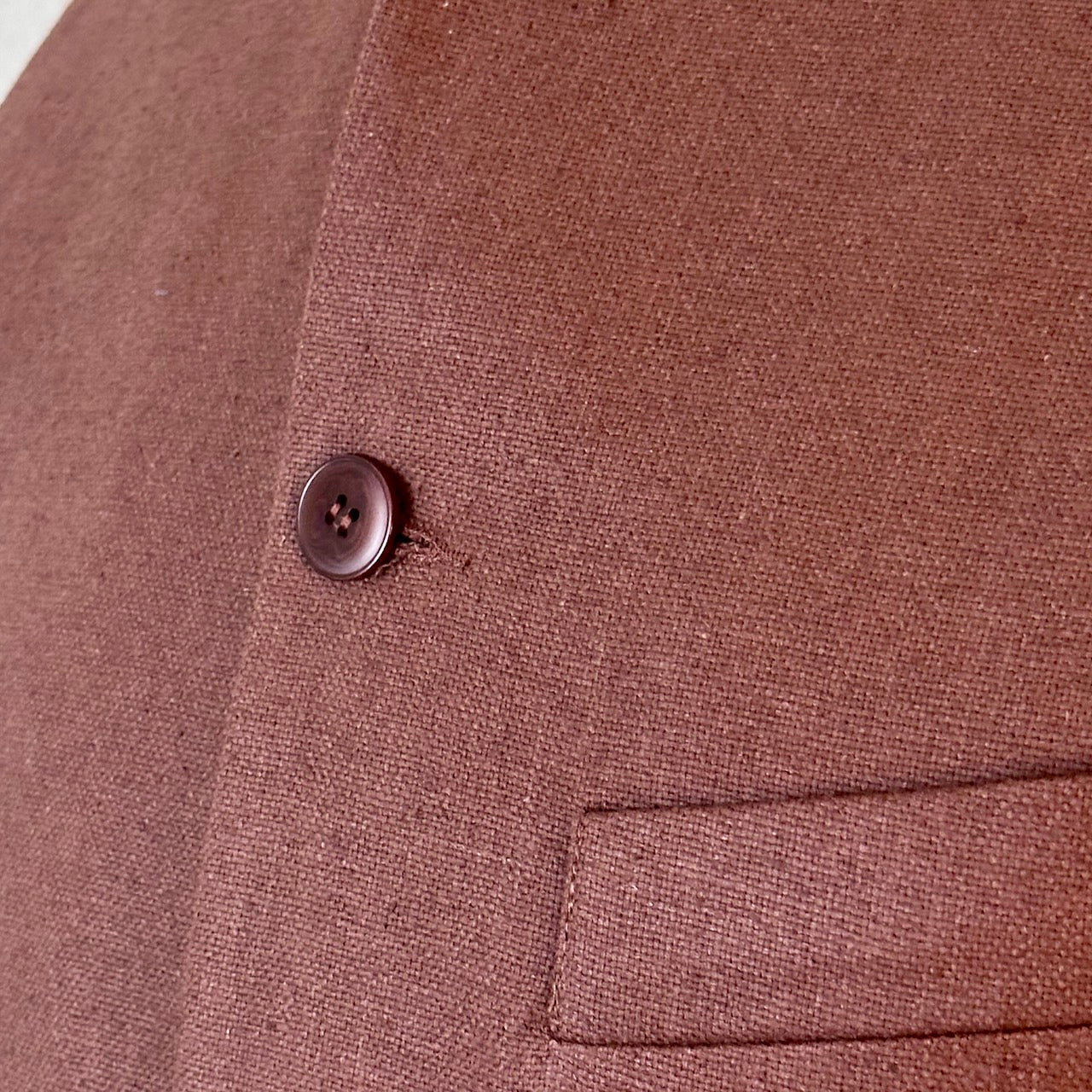Close up shot showing fabric detail of loose fitting summer weight Nehru Style gilet in brown silk matka. Handmade in London. Lined in Cotton Ticking.