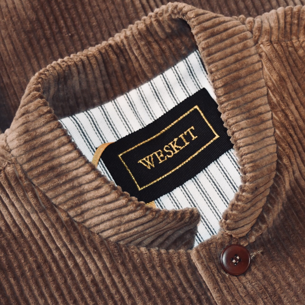Collar Detail on Light Brown Nehru-Style Slim Cut Gilet. This fitted waistcoat has a pure cotton cord outer and pure cotton ticking lining. Handmade in London it is the prefect alternative to a jacket or jumper in the cooler seasons.