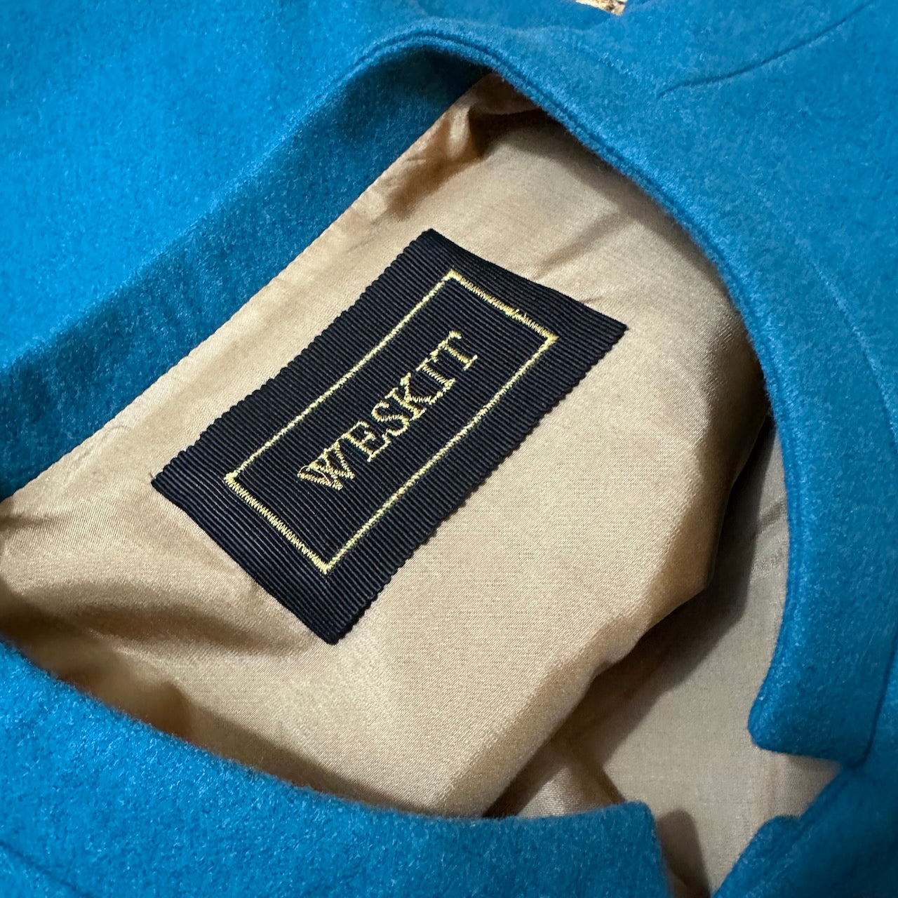Petrol Merino Flannel Gilet showing embroidered label and Fawn Viscose Lining. Handmade in Britain.