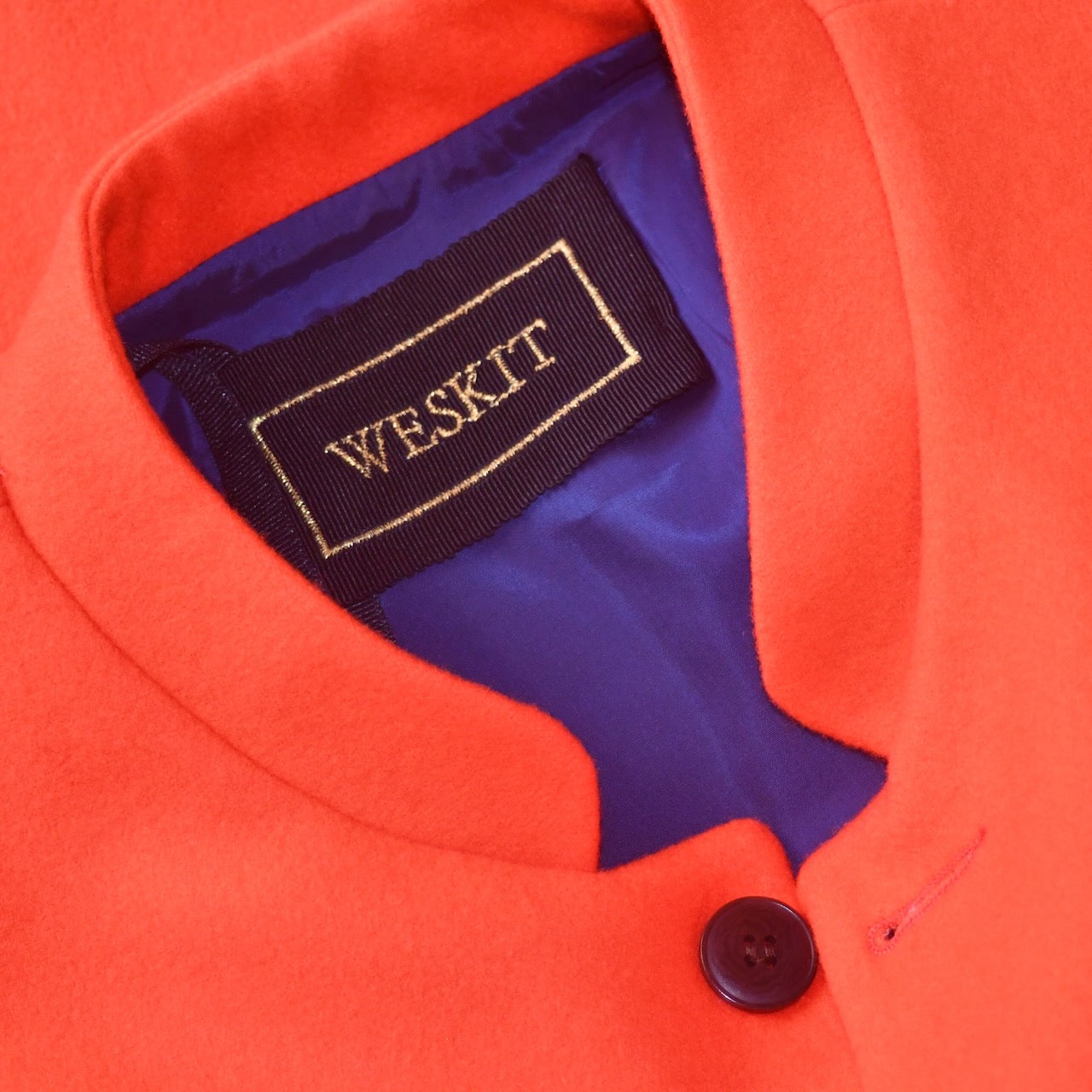 Collar Detail on a bright orange Nehru Style Gilet in pure merino wool flannel. Woven in Yorkshire this merino melton has a wonderful handle and a lovely warm weight to it. Handmade in London, this gilet has three outer and two inner pockets and side vents for ease when seated.
Cut,  Made and Finished by Hand in London. Woven in Yorkshire, with buttons from Gloucestershire - a truly British Waistcoat.
