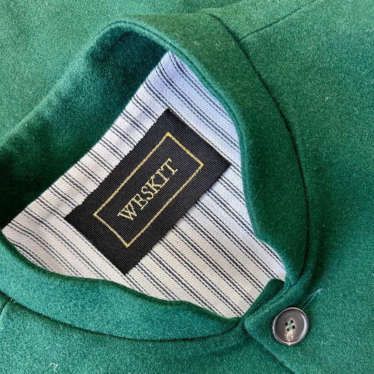 Slim Cut Nehru Style Gilet in bottle or British racing green pure merino flannel. This pure wool gilet is hand made in London. The thick merino wool flannel is woven in Yorkshire by AW Hainsworth. A perfect Town-to-Country dressing solution. Detailed Collar View showing striped cotton ticking lining and embroidered Weskit label.