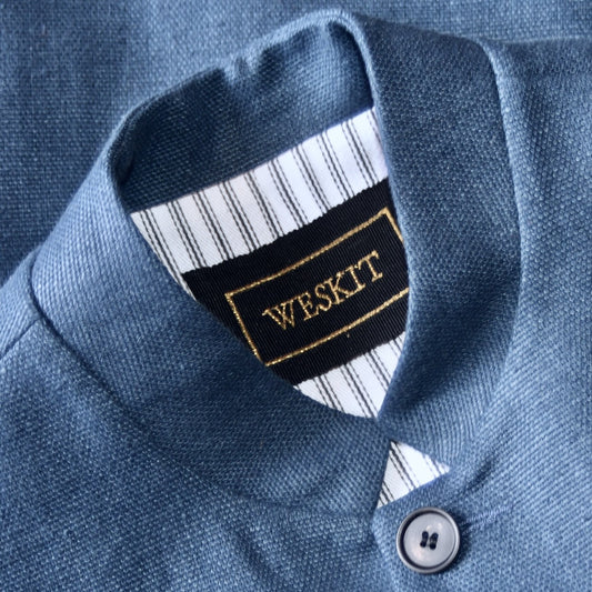 Nehru Style Gilet in Heavy Blue Linen. Irish Linen Gilet, Made by Hand in London. Entirely made in Great Britain. Close up on Nehru Collar showing Striped Cotton Ticking Linen and embroidered label on black ribbed silk.