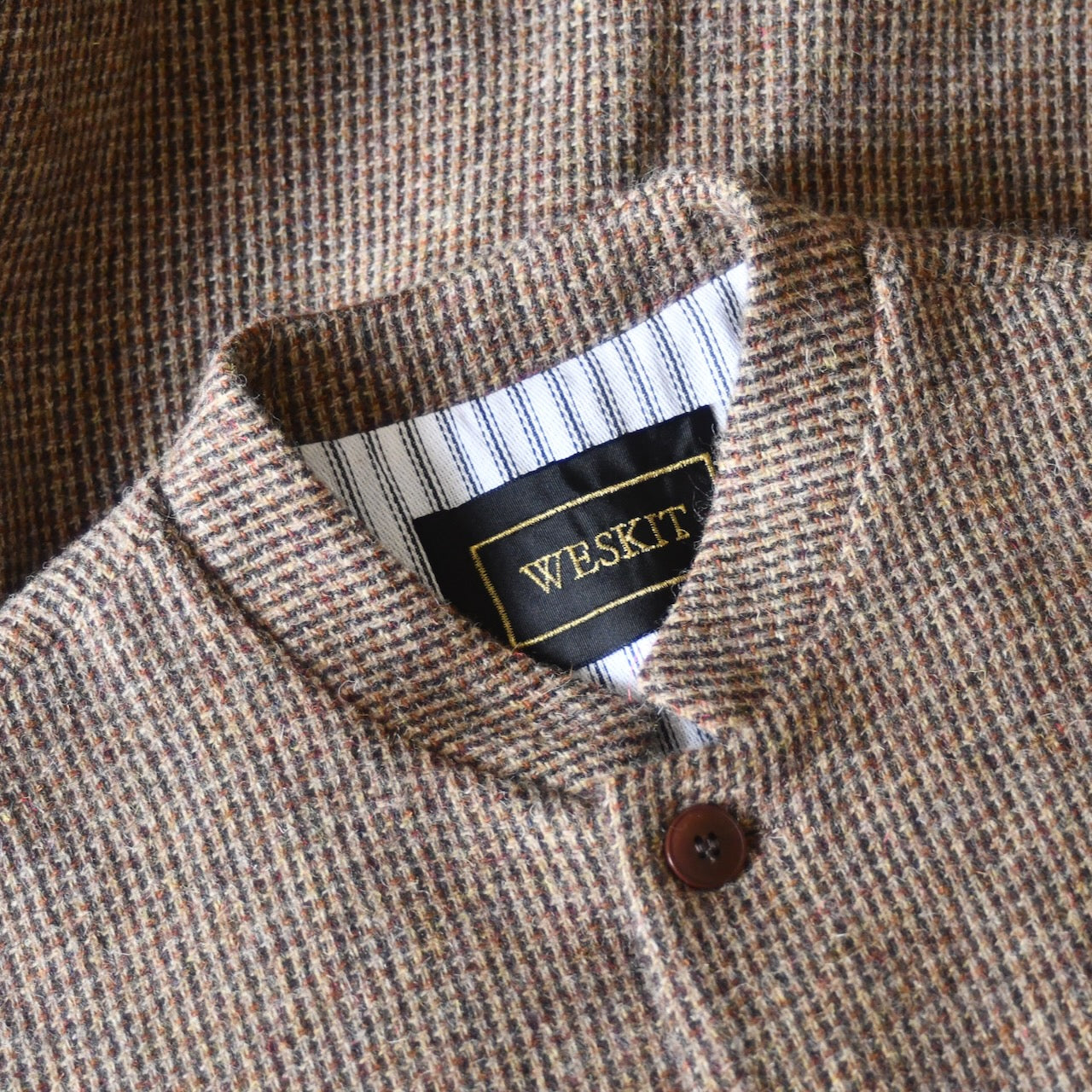 Collar close up shot showing Nehru collar on Slim Fit Nehru-style gilet in light brown patterned pure wool tweed. With an outer from Lovat Mill, this ticking-lined gilet is handmade in London. Bespoke sizing available.