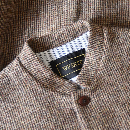 Collar close up shot showing Nehru collar on Slim Fit Nehru-style gilet in light brown patterned pure wool tweed. With an outer from Lovat Mill, this ticking-lined gilet is handmade in London. Bespoke sizing available.