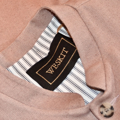 Slim fit Nehru style gilet for spring summer wear. Handmade in London this purse silk waistcoat is fully lined, has a Nehru collar and five corozo buttons to the front. With three outside and two inside pockets it is a perfect alternative to a jacket in summer. Pale Pink. Close up on collar showing cotton ticking lining and black silk embroidered label.