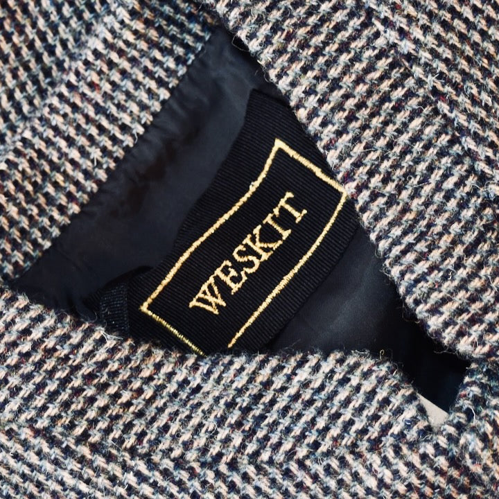 Collar Detail of Warm Nehru Style Gilet in pure wool tweed from Hawick. Handmade in London this waistcoat has a gentle patterning in blue and shades of taupe and grey. Ample pocket space, side vents and a nead Mandarin Collar.