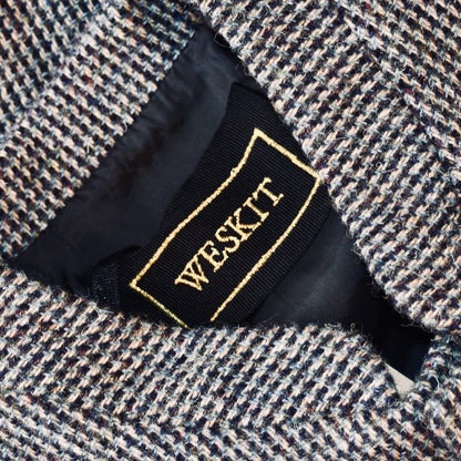 Collar Detail of Warm Nehru Style Gilet in pure wool tweed from Hawick. Handmade in London this waistcoat has a gentle patterning in blue and shades of taupe and grey. Ample pocket space, side vents and a nead Mandarin Collar.