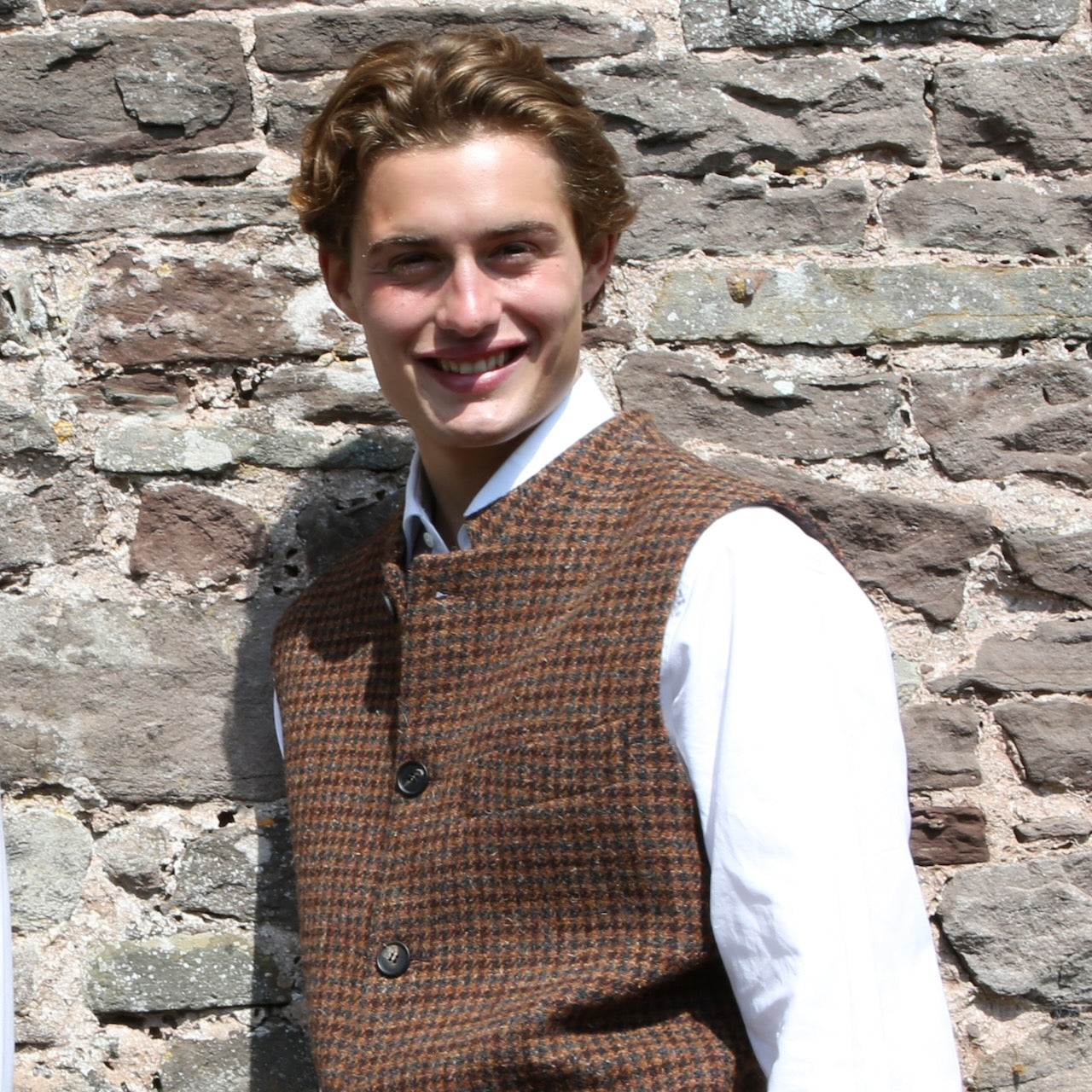 Fitted Cut Nehru-Style Gilet in Copper Check Lovat Tweed A tailored cut waistcoat imade up in a wonderfully deep coppery checked British Wool tweed by Lovat Mill. An incredibly warm and well-made tweed in a stunning, unusual and very wearable heathery colour which bears green, russet brown, and blue checks against a dark straw background.