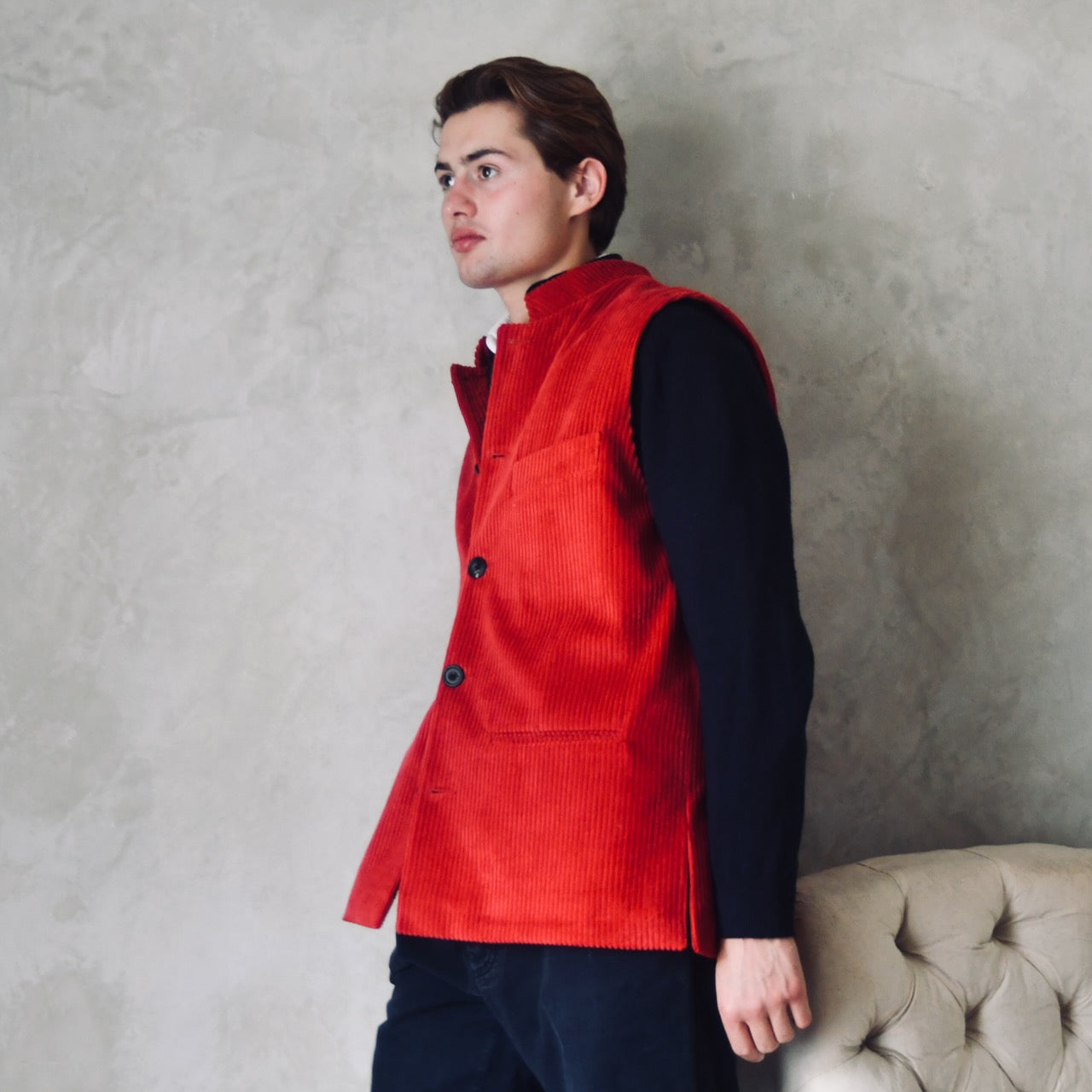 Relaxed Fit Nehru-Style Gilet in Claret Corduroy. This pure cotton corduroy gilet is lined in striped cotton ticking. With a Nehru collar and five pockets it can be dressed up or down. Two side lits for comfort. Handmade in London. Side on View.