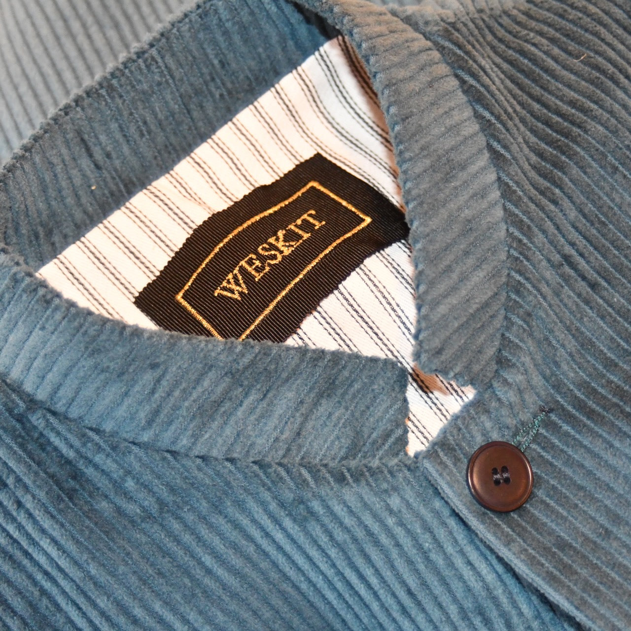 Detail shot showing striped cotton ticking lining and embroidered silk label on Teal Blue Corduroy Nehru Style Gilet. Handmade in London. Pure Cotton.