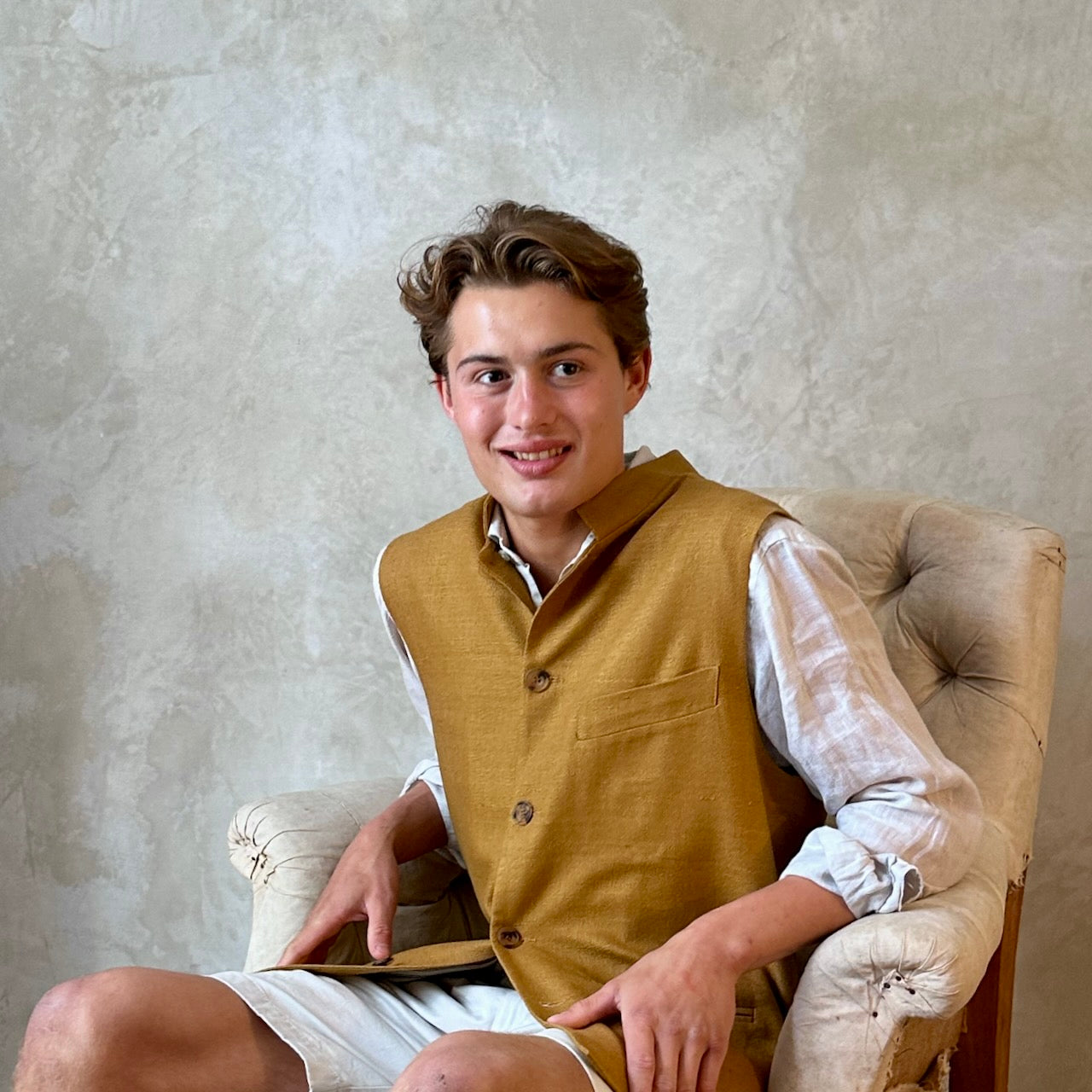The perfect alternative to a jacket on hotter days, this summer weight slim fit gilet is handmade in London. Made up in a pure silk matka, the waistcoat is fitted and fully lined with two inside and three outside pockets. Seated View.