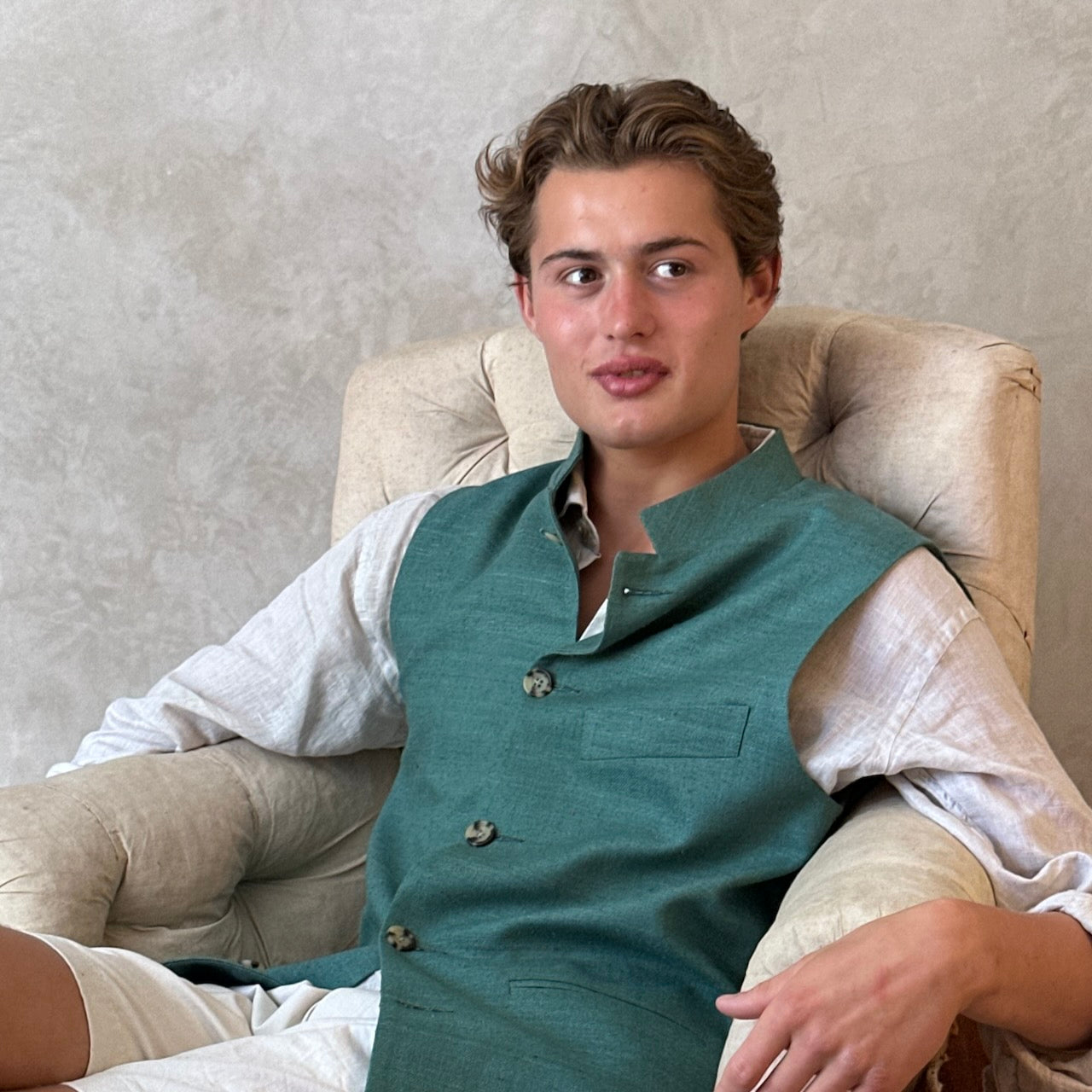 A superb alternative to a jacket in spring and summer or for evening wear with a neat cut and ample pocket space. This pure silk Nehru Style Gilet is handmade in London. Bespoke Options available. Modelled Seated Shot.