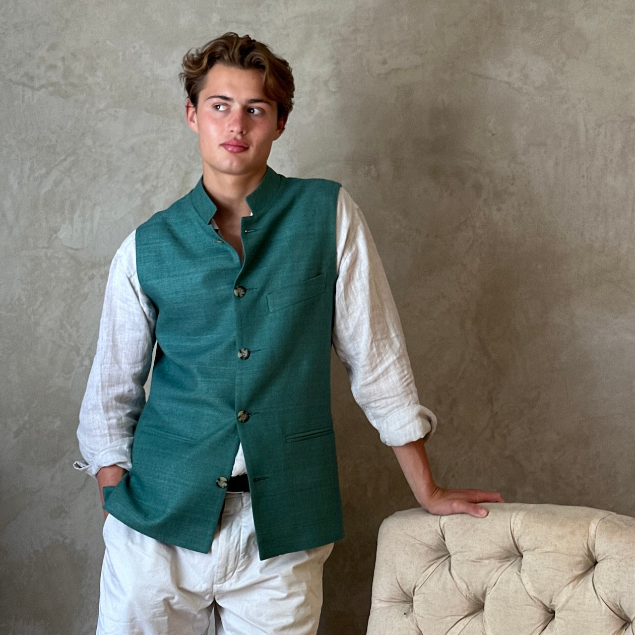 A superb alternative to a jacket in spring and summer or for evening wear with a neat cut and ample pocket space. This pure silk Nehru Style Gilet is handmade in London. Bespoke Options available. Modelled Standing shot showing gilet fully buttoned.