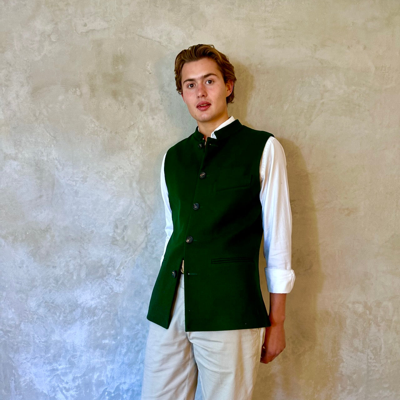 Slim Cut Nehru Style Gilet in bottle or British racing green pure merino flannel. This pure wool gilet is hand made in London. The thick merino wool flannel is woven in Yorkshire by AW Hainsworth. A perfect Town-to-Country dressing solution. Front View.