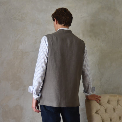 Spring summer relaxed fit Nehru style gilet in slubby Irish linen. This browning coloured linen waistcoat is fully lined in pure cotton ticking. With three outside and two inside pockets it is the perfect alternative to a jacket on warmer days. Made by Hand in Britain. Rear View.