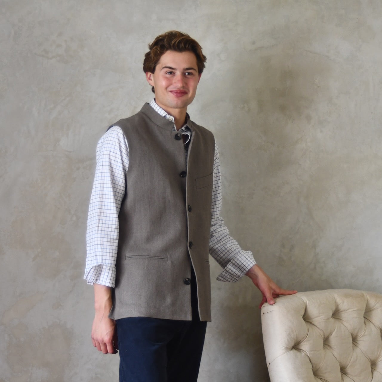 Nehru-style fitted gilet in relaxed brown Irish linen. Handmade in London this slim-cut waistcoat has a Nehru collar, is fully lined in pure cotton ticking and has five pockets. Standing buttoned shot.