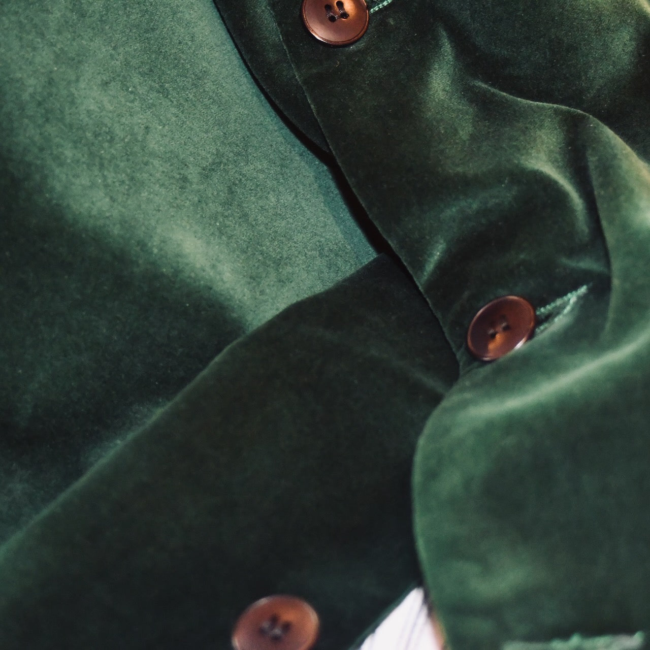 Button Detail Shot of Bottle Green Velvet Nehru-Style Gilet showing ticking lining and embroidered label.
Handmade in London.
Entirely made in Great Britain.