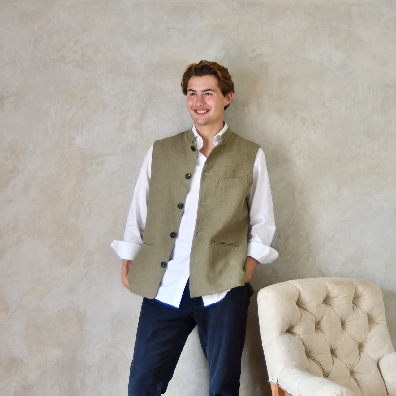 Relaxed fit nehru-style gilet in khaki linen. Handmade in London this is a very relaxed waistcoat and a perfect summer alternative to a jacket. Midweight and slubby, the linen outer is fully lined in pure cotton ticking. Unbuttoned View.