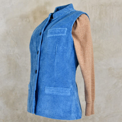 Side view of Blue Cotton Corduroy Ladies Waistcoat. 
Handmade in London this longer length Gilet has a Nehru collar and bllue corozo buttons.
