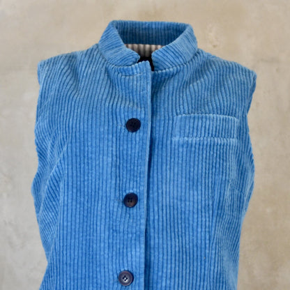 Close Up view of Blue Cotton Corduroy Ladies Waistcoat. 
Handmade in London this longer length Gilet has a Nehru collar and bllue corozo buttons.