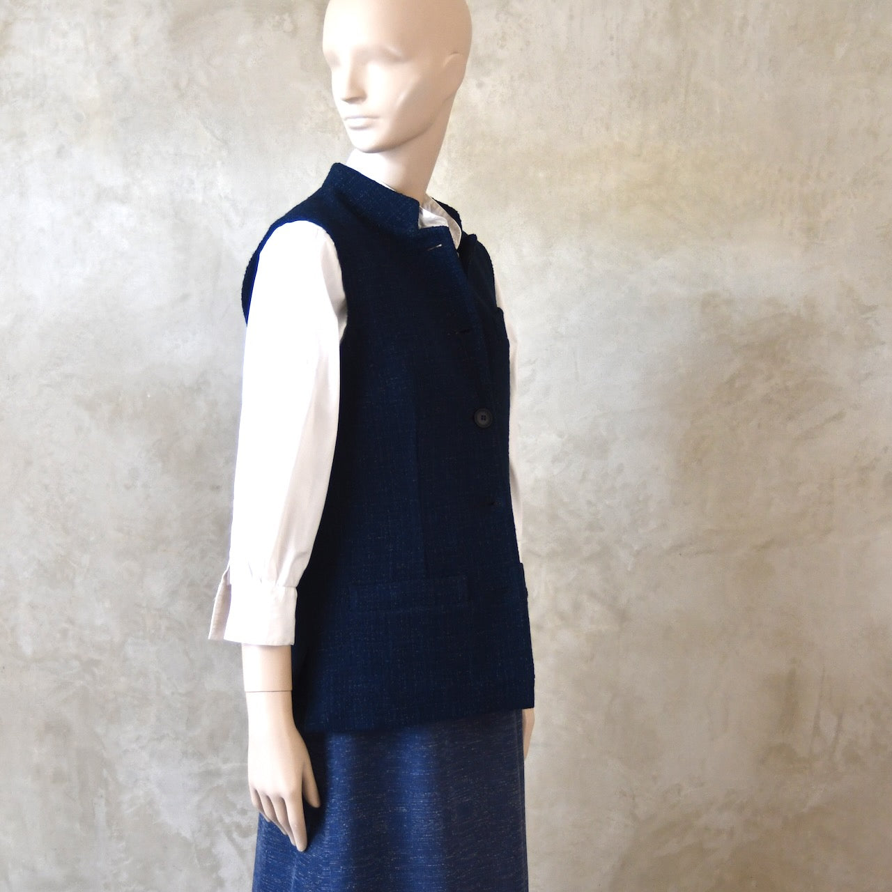 Side Shot of Ladies Shaped Gilet in Linton Tweeds boucle. A deep navy spring-summer weight fabric, this gilet packs superbly and can be worn everywhere. Handmade in London. 