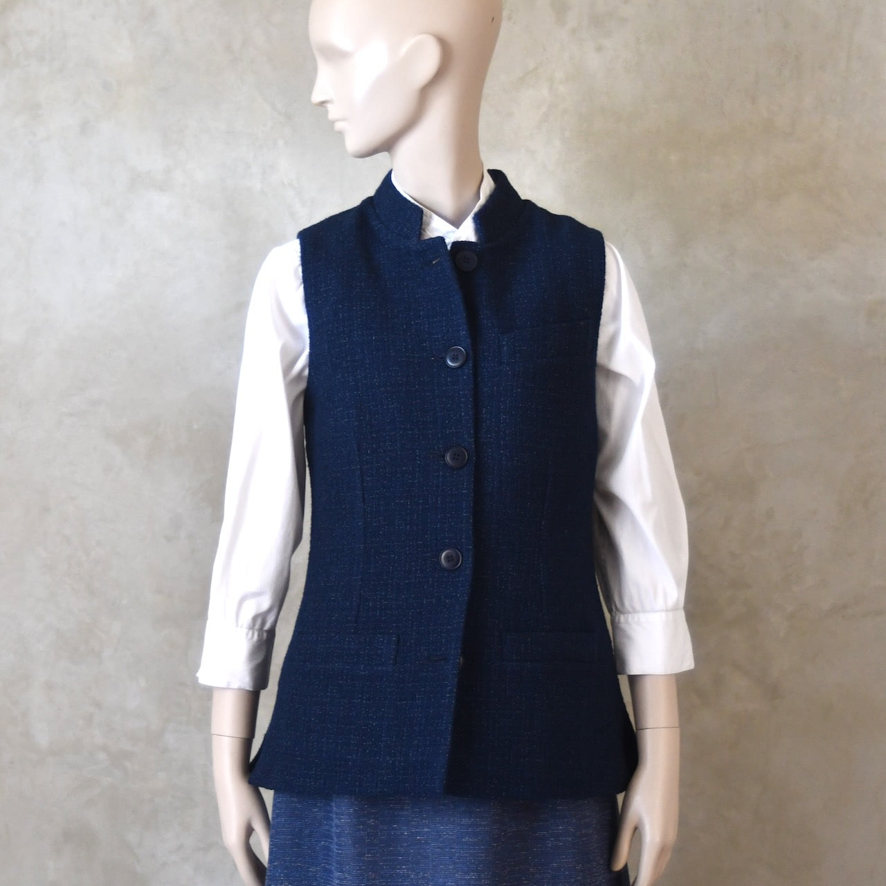 Buttoned front Shot of Ladies Shaped Gilet in Linton Tweeds boucle. A deep navy spring-summer weight fabric, this gilet packs superbly and can be worn everywhere. Handmade in London. 