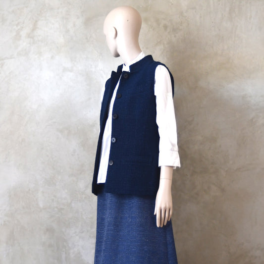 Angled Side Shot of Ladies Shaped Gilet in Linton Tweeds boucle. A deep navy spring-summer weight fabric, this gilet packs superbly and can be worn everywhere. Handmade in London. 