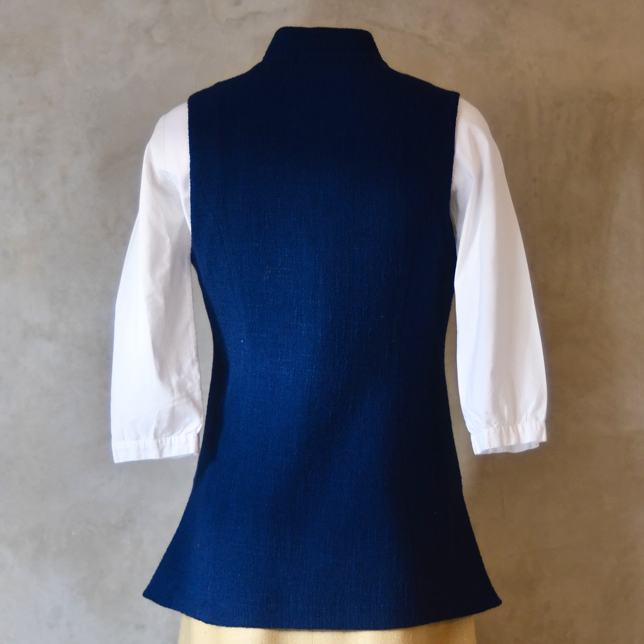 Rear shot of Navy Ladies' Waistcoat in Linton Tweeds Boucle. This pure cotton boucle has a lightweight feel and a gentle handle. Perfect for spring, autumn and cooler summer days. Handmade in London.