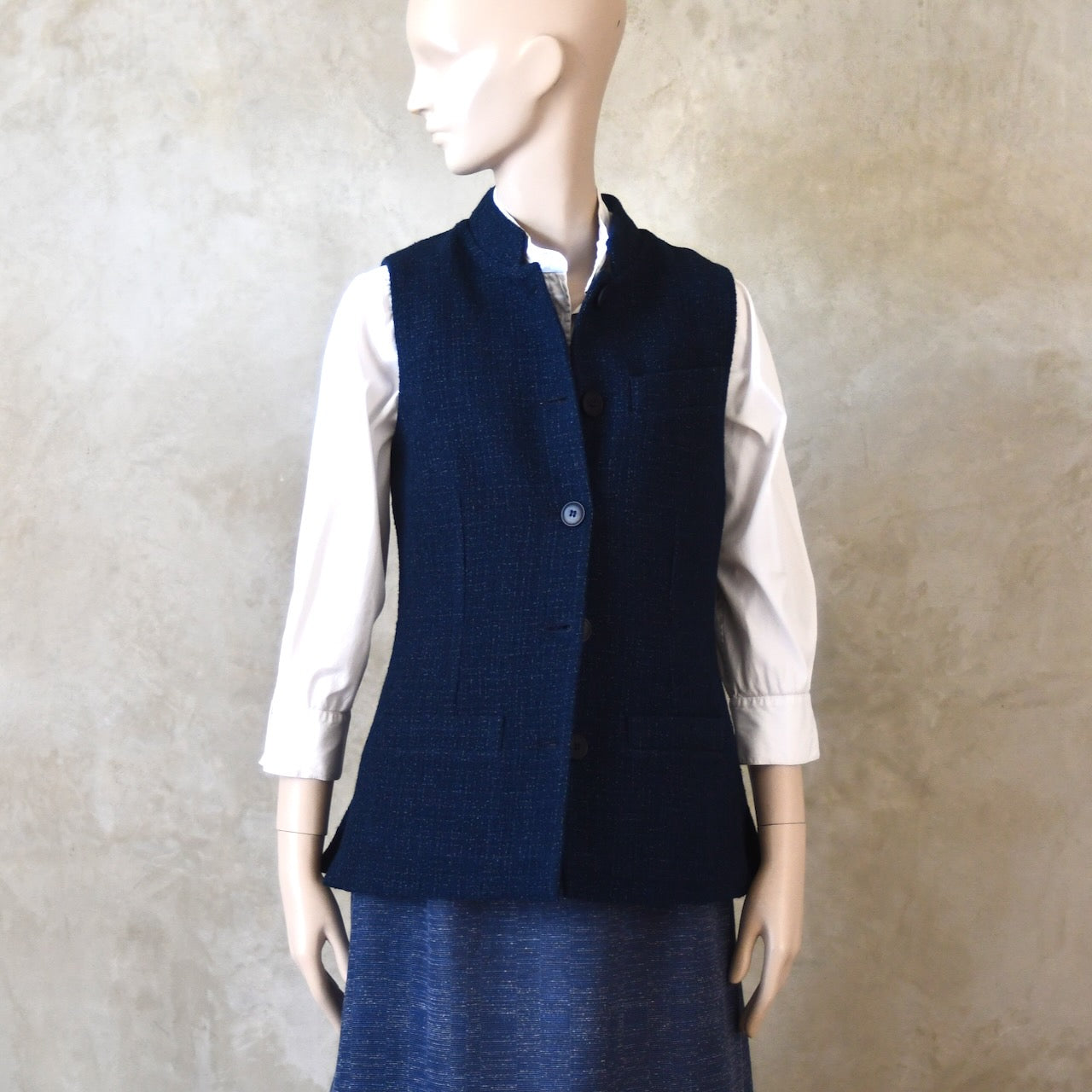 Side Shot of Ladies Shaped Gilet in Linton Tweeds boucle. A deep navy spring-summer weight fabric, this gilet packs superbly and can be worn everywhere. Handmade in London. 