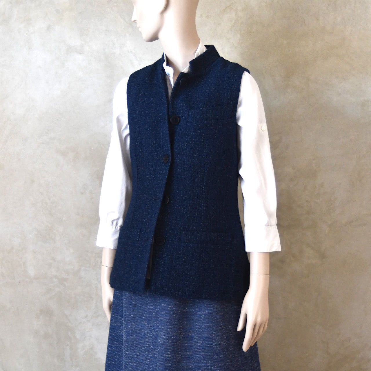 Buttoned Front Side Shot of Ladies Shaped Gilet in Linton Tweeds boucle. A deep navy spring-summer weight fabric, this gilet packs superbly and can be worn everywhere. Handmade in London. 