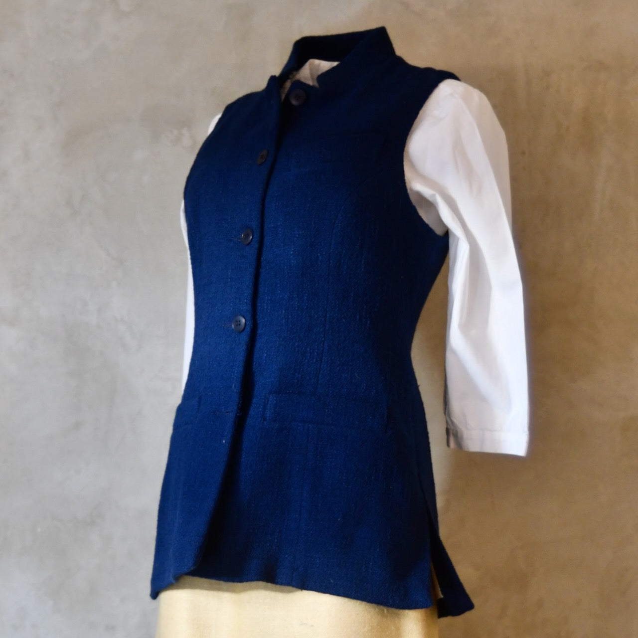 Side shot of Navy Ladies' Waistcoat in Linton Tweeds Boucle. This pure cotton boucle has a lightweight feel and a gentle handle. Perfect for spring, autumn and cooler summer days. Handmade in London.