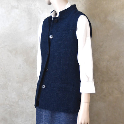 Angled Side Shot of Ladies Shaped Gilet in Linton Tweeds boucle. A deep navy spring-summer weight fabric, this gilet packs superbly and can be worn everywhere. Handmade in London.  Buttoned up view.