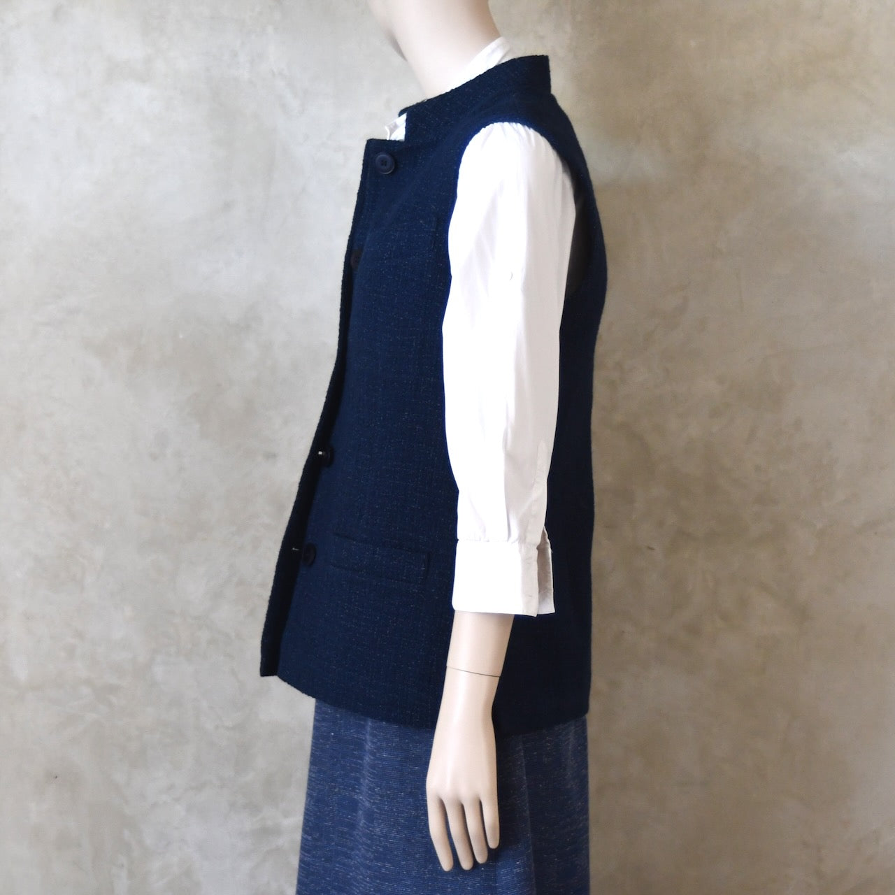 Buttoned side shot of Ladies Shaped Gilet in Linton Tweeds boucle. A deep navy spring-summer weight fabric, this gilet packs superbly and can be worn everywhere. Handmade in London. 