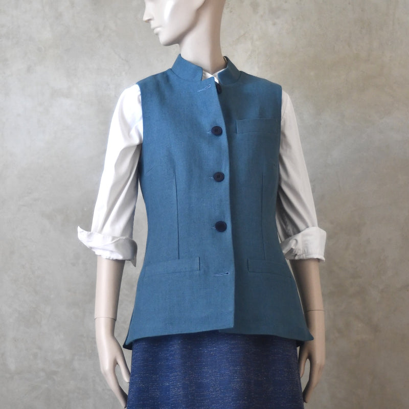 Front View of Ladies Gilet in Light Blue Irish Linen. Handmade in London this waistcoat has a Nehru collar, cotton ticking lining, bust darts as well as front and rear waist-shaping darts.