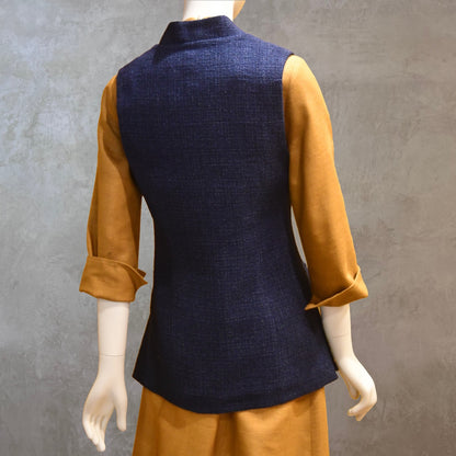Back Detail on Longer Length Ladies Waistcoat in Linton Tweeds Boucle. A pure cotton weave,  this is superbly trans-seasonal option. Handmade in London. Shown over mustard coloured Silk Matka Dress from Ednerat.