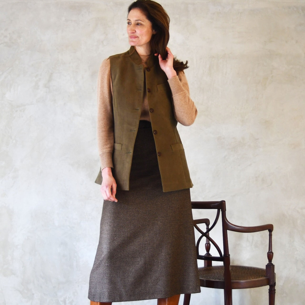 Long view of Ladies Shaped Waistcoat in poure cotton Khaki Moleskin. 
Handmade in London, this waistcoat is an easy to wear and elegant alternative to a jumper or jacket.
Shown worn over skirt.