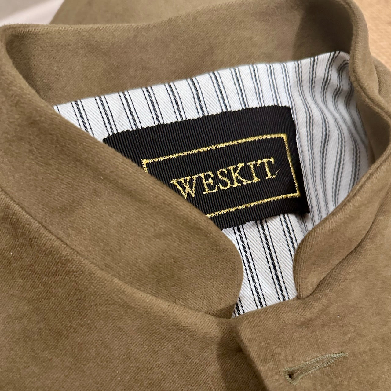 Collar close up view of Ladies Shaped Waistcoat in poure cotton Khaki Moleskin. 
Handmade in London, this waistcoat is an easy to wear and elegant alternative to a jumper or jacket.