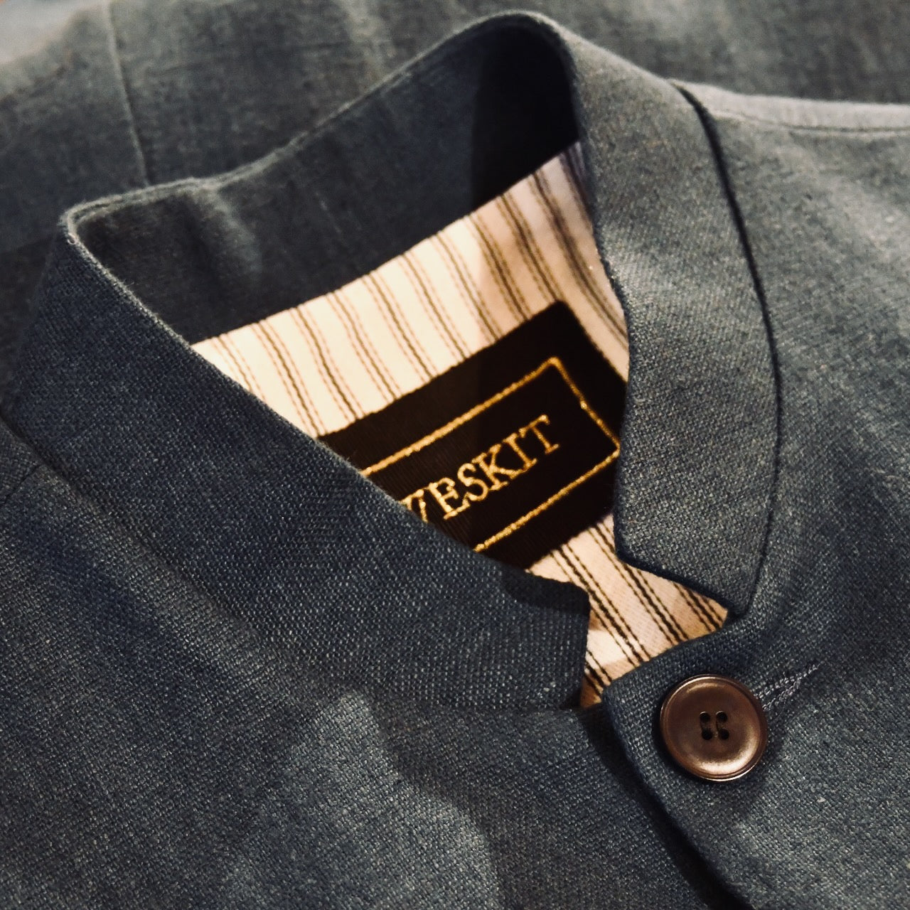 Collar Detail of Loose cut Nehru Style Gilet in Deep Navy Linen. This handmade gilet is made from a relaxed mid weight Irish linen. With e Nehru collar detail, three external pockets and a five-buttoned front it is smart enough for work - and yet perfect for the weekend. Fully Lined in Cotton Ticking.